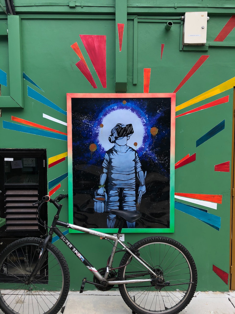 A street art poster of an artist wearing VR goggles